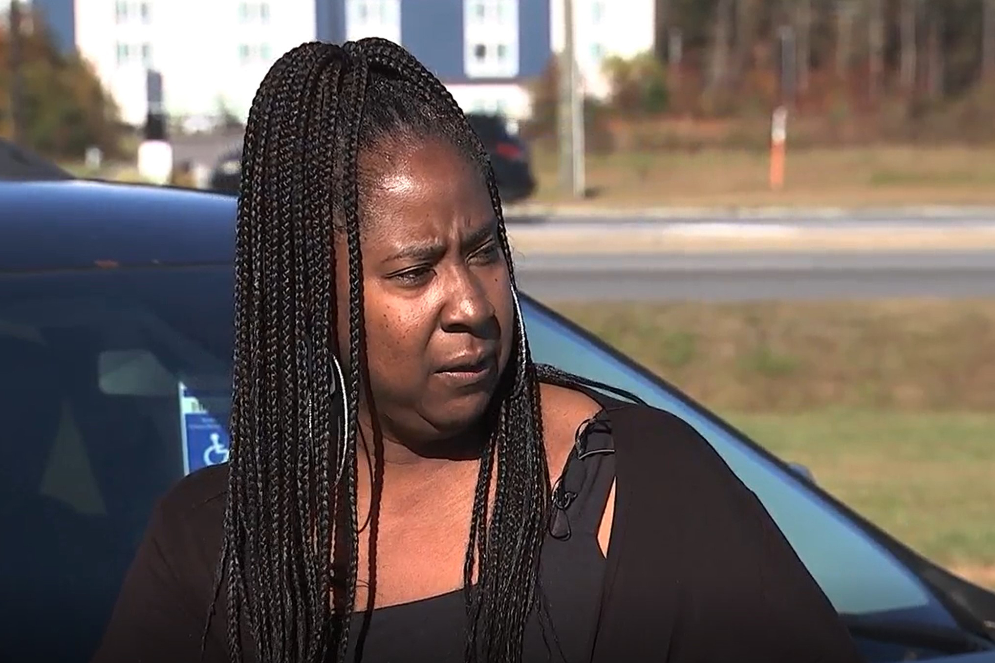 A photo of Denise Woods by her car outside.