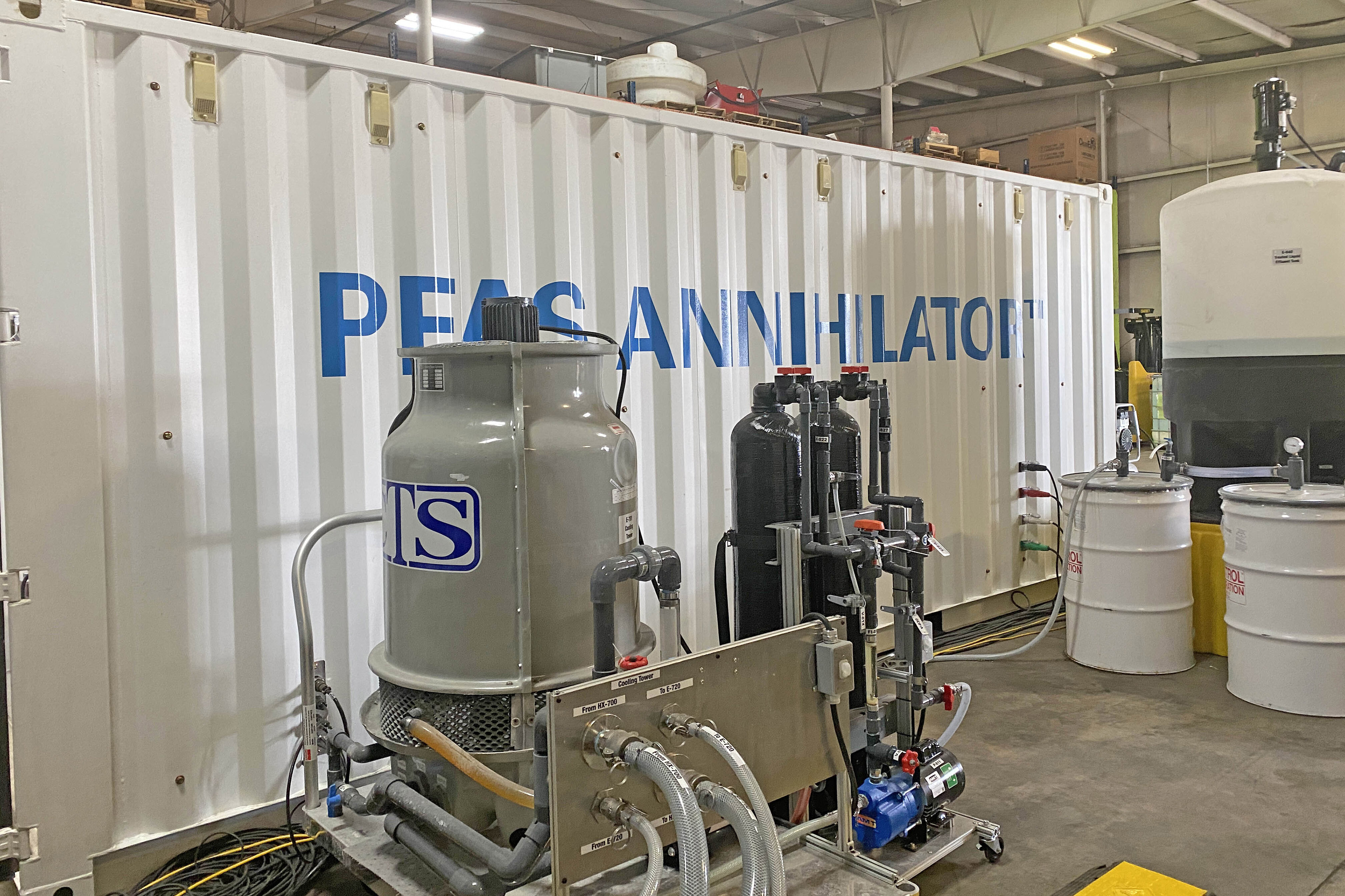 A photograph of a mobile supercritical water oxidation system, called the “PFAS Annihilator,” that is the size of two shipping containers and operates at a wastewater treatment facility.