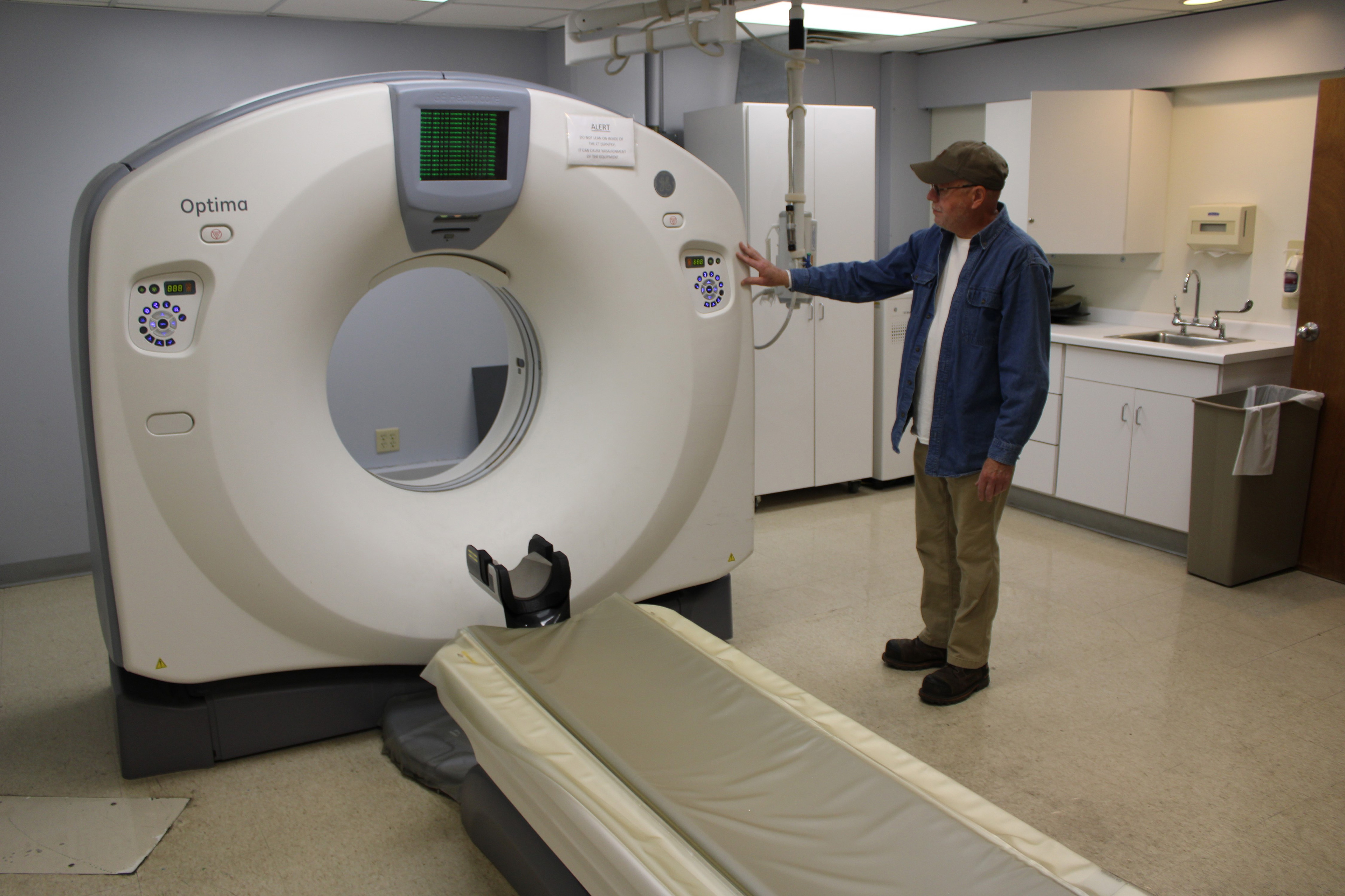 Bruce Mackie, a longtime employee of the hospital in Keokuk, Iowa, looks at a CT scanner waiting to be used again.