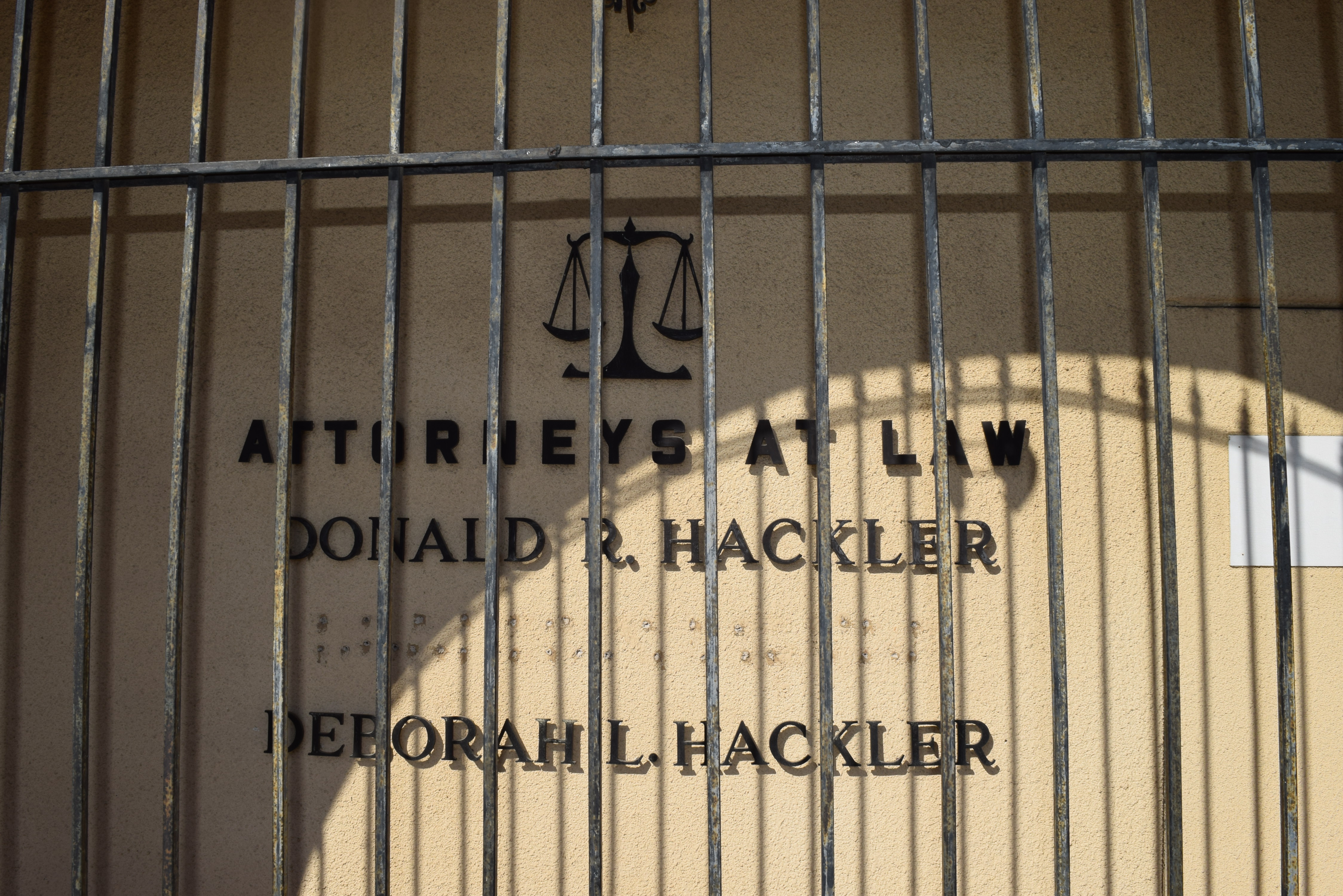 A cream wall, the front of an office, with black lettering reading "Donald R. Hackler" on one line and "Deborah L. Hackler" on another.