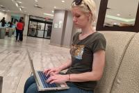 A photo of a woman using a laptop indoors.