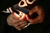 A photo of a person's hands holding a lighter under a piece of foil with fentanyl.