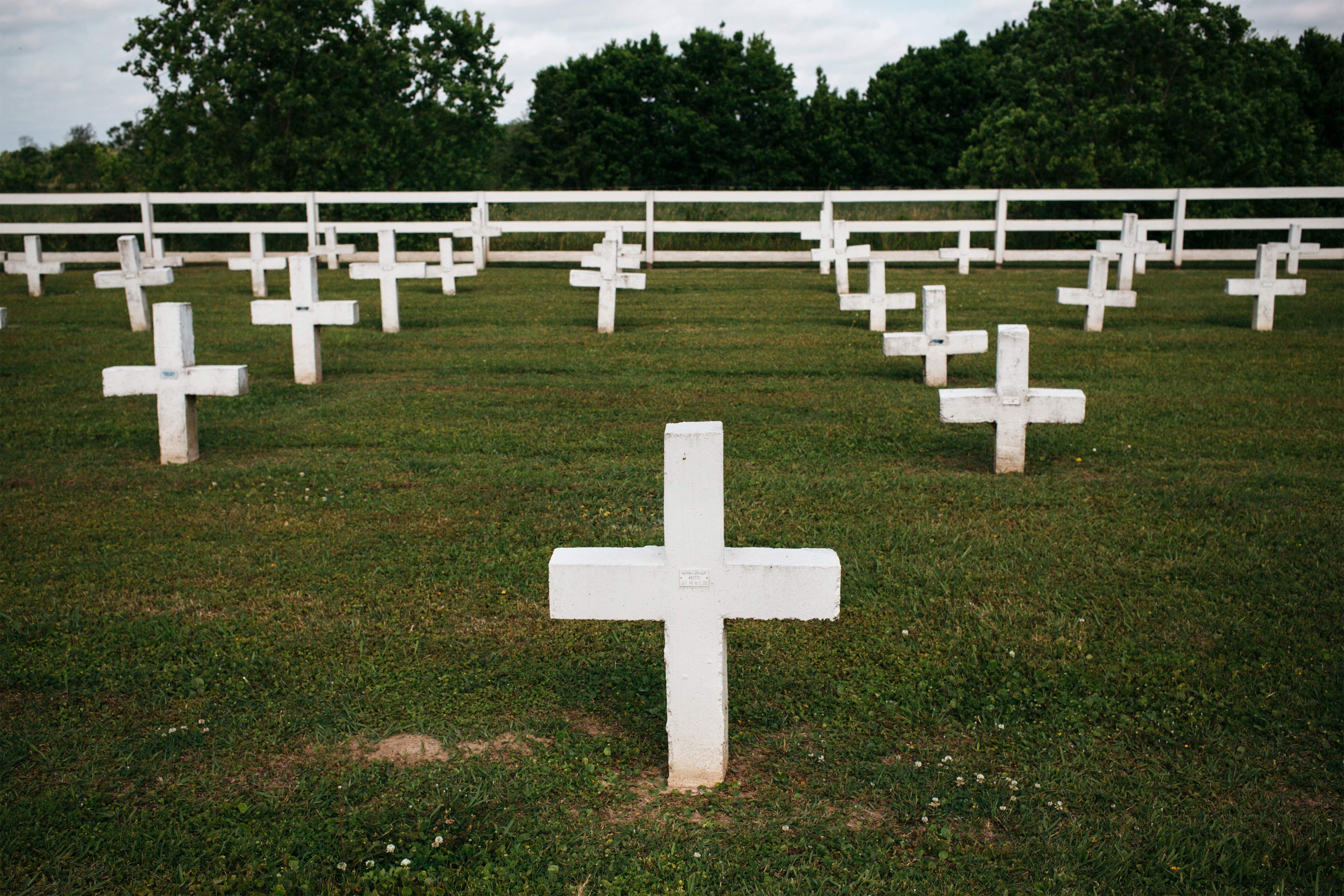 A photo of a cemetery grounds at a prison. Rows of white crosses are seen.