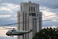A photo of a helicopter taking off in front of a large hospital building.