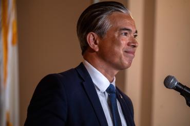 A photo of Rob Bonta speaking in front of a microphone.