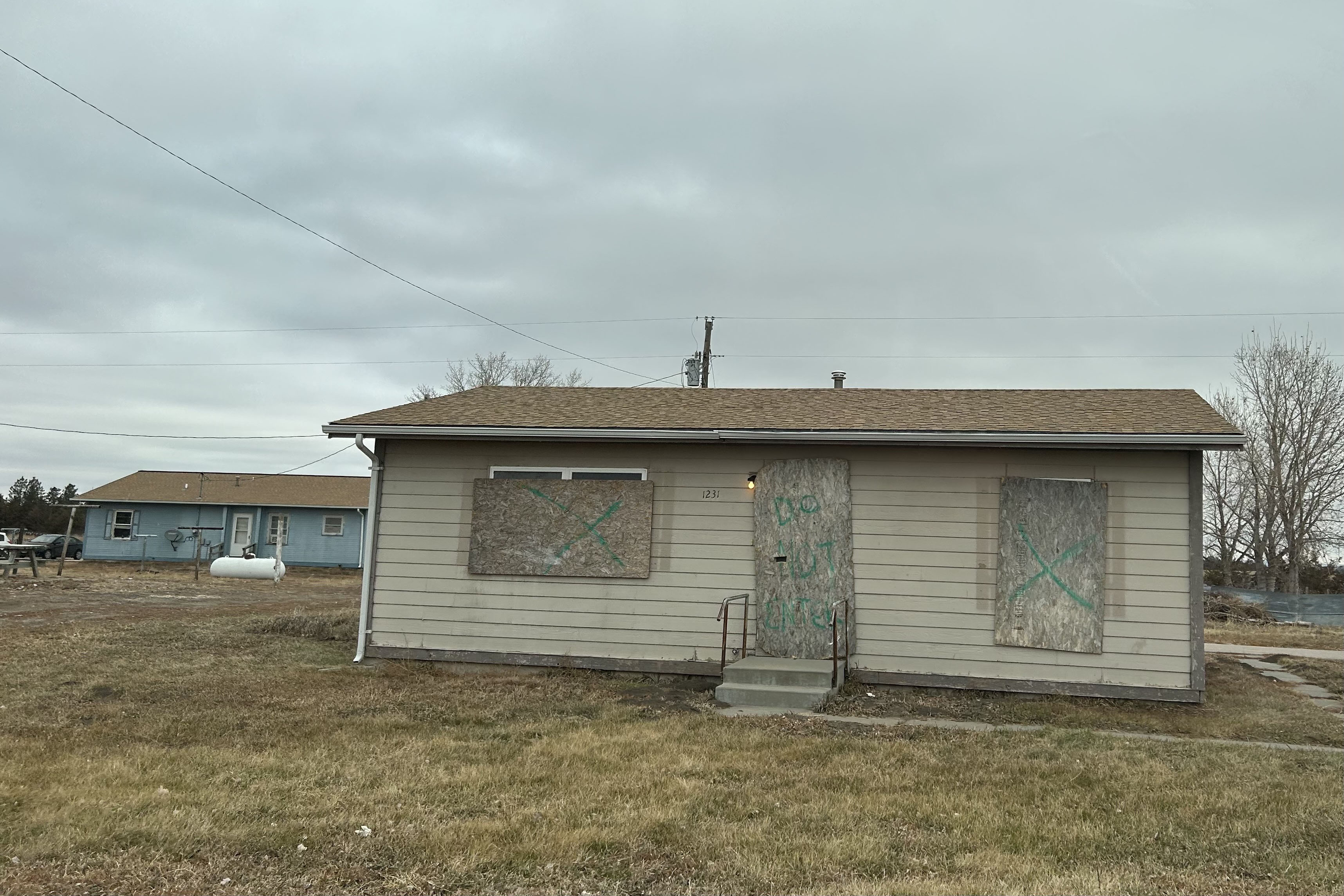 A single-story home in Martin, South Dakota, that has boards over the windows and doors.