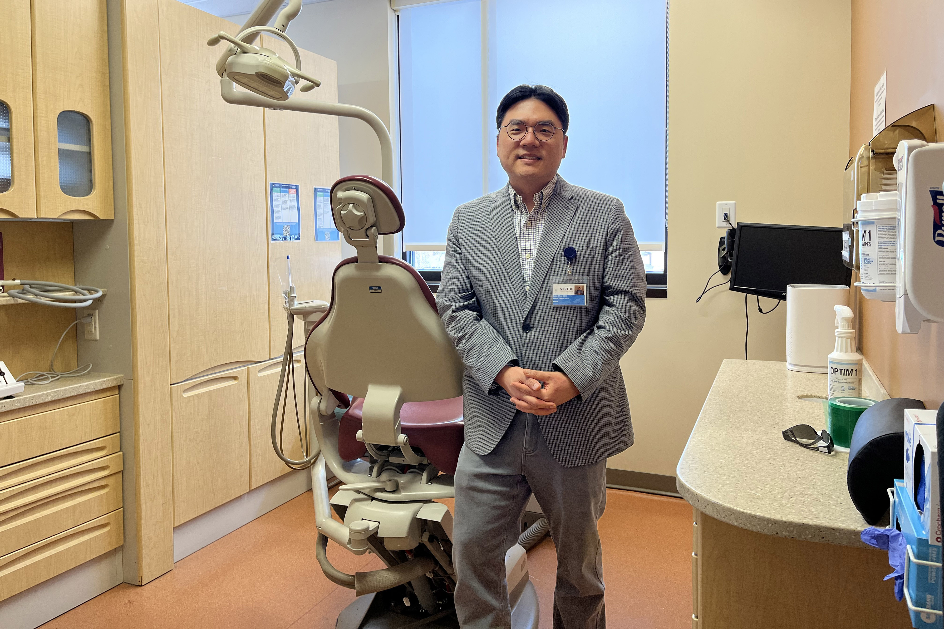 Sung Cho stands in an empty dental exam room.