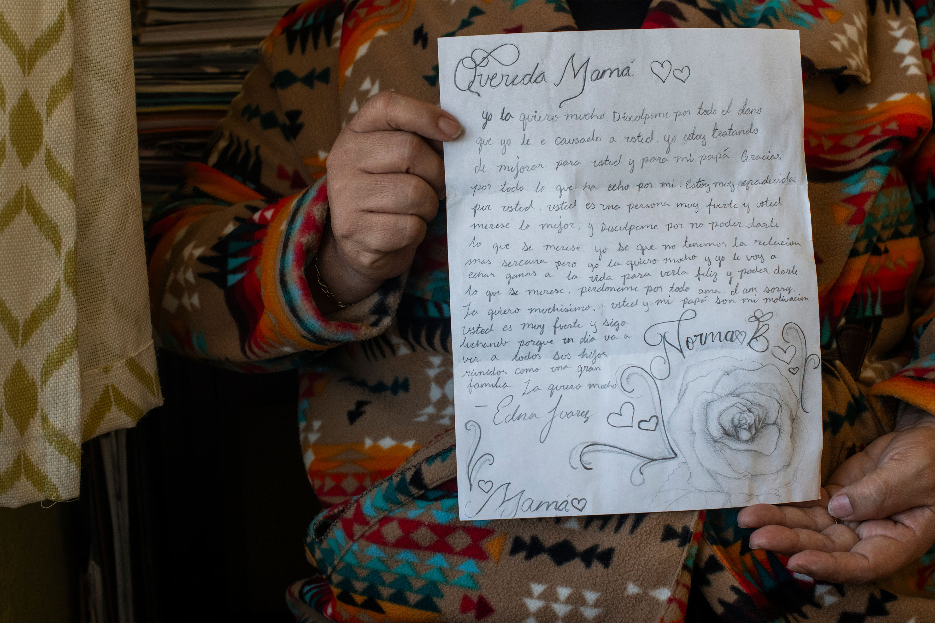 A photo of a woman holding a letter from her daughter.