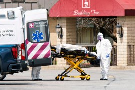 A photo from 2020 of medical workers loading a dead body into an ambulance while wearing masks and personal protective equipment at Andover Subacute and Rehabilitation Center in New Jersey.