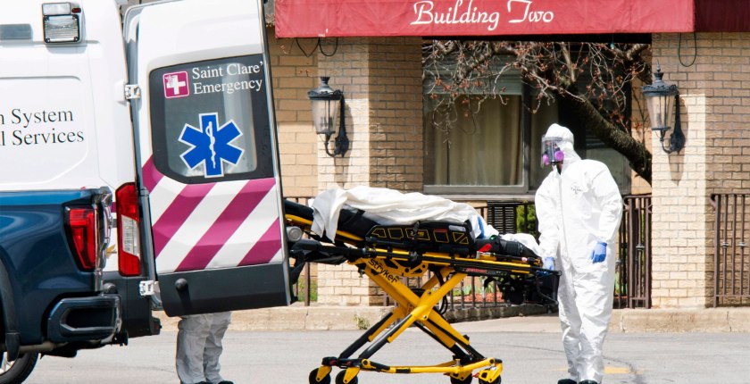 A photo from 2020 of medical workers loading a dead body into an ambulance while wearing masks and personal protective equipment at Andover Subacute and Rehabilitation Center in New Jersey.