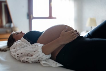 A pregnant woman is lying in bed.