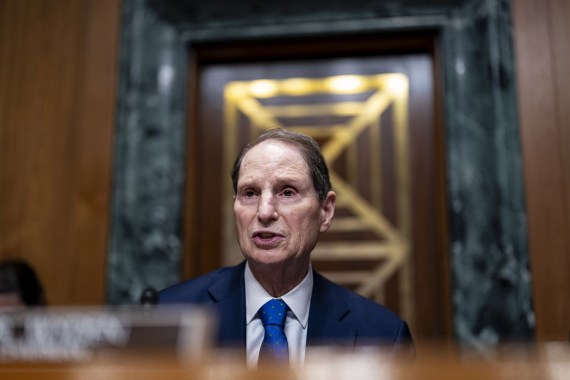 A man wearing a blue suit and blue tie speaks while seated at a table during a hearing in Washington, D.C.
