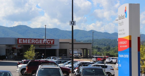 A photo of a hospital parking lot and emergency room entrance.