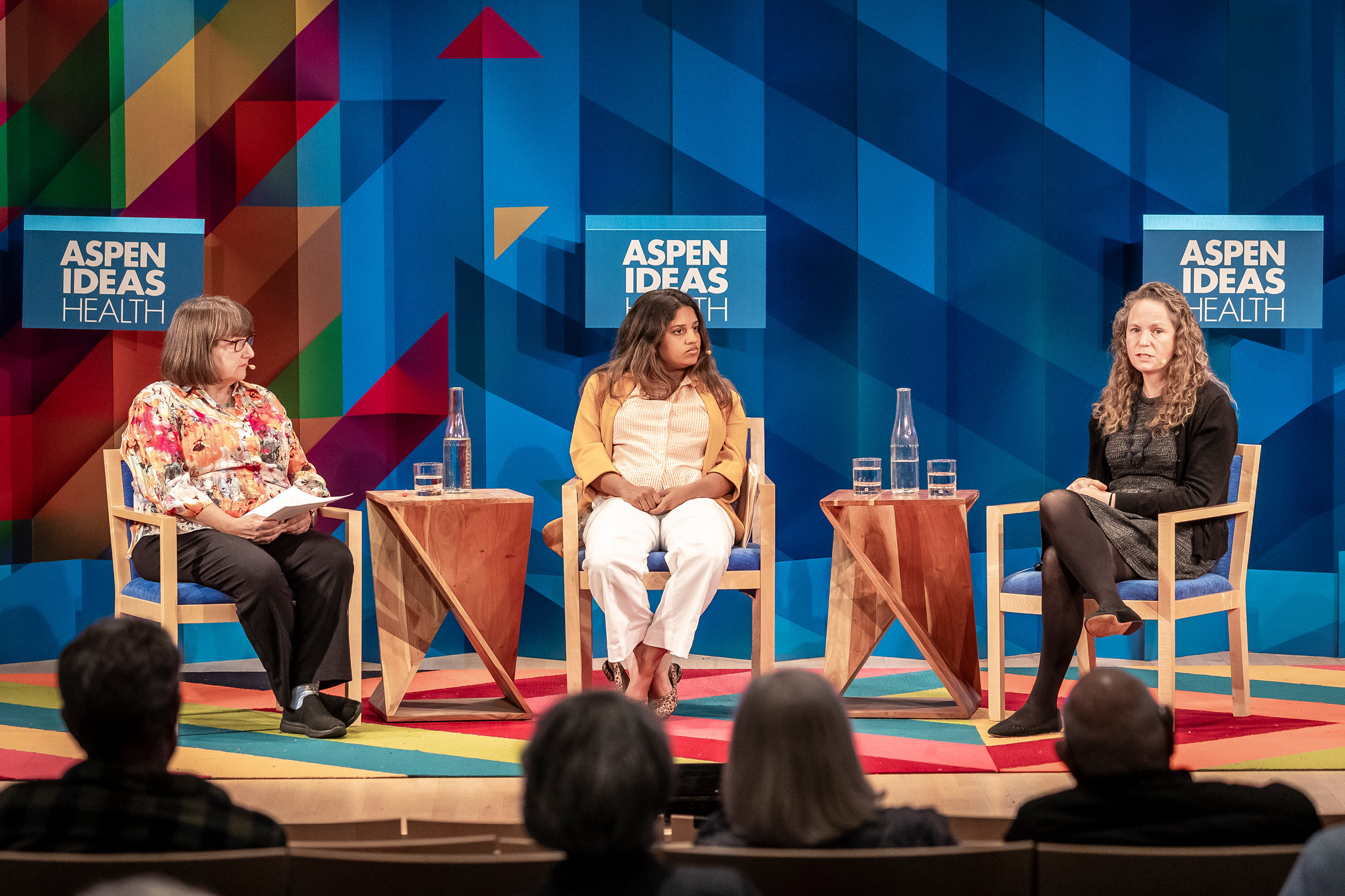 A photo of Julie Rovner, Sandhya Raman, and Margot Sanger-Katz on a stage, speaking to one another.