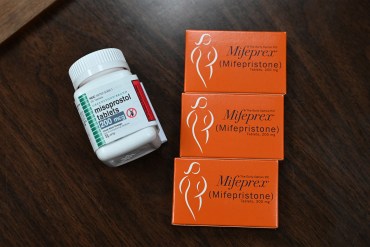 A photo of boxes of mifepristone and next to a pill bottle of misoprostol.