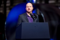 A photo of Governor Jared Polis as a podium speaking.
