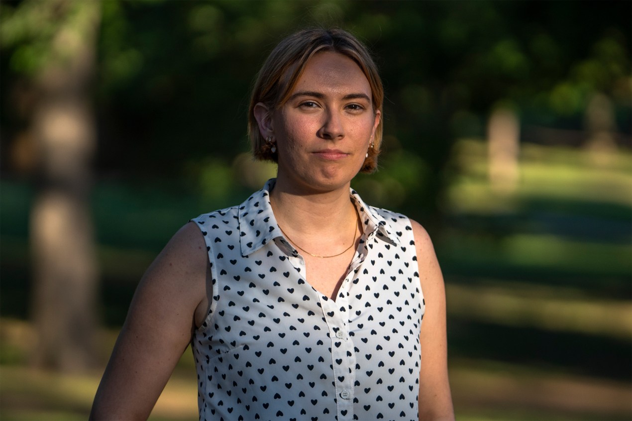 A portrait of a woman standing outside.