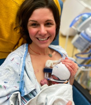 A woman with short brown hair holds a baby on her chest in a hospital bed