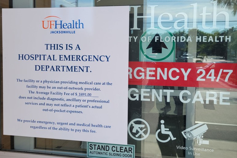 A paper sign on the front door at a UF Health emergency and urgent care facility notifies patients they may be billed for emergency services.