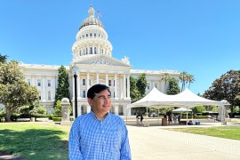 A photo of a man standing outside California's capitol.