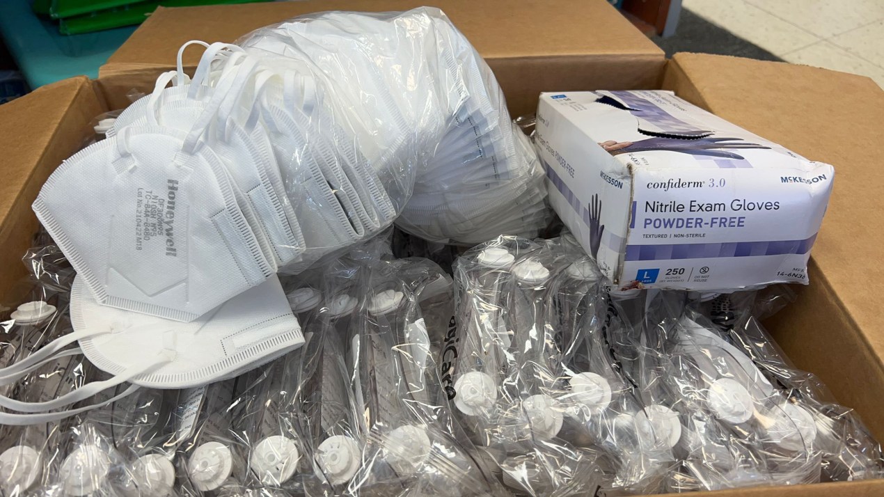 a box containing N95 masks, a small box of gloves, and plastic, clear goggles 