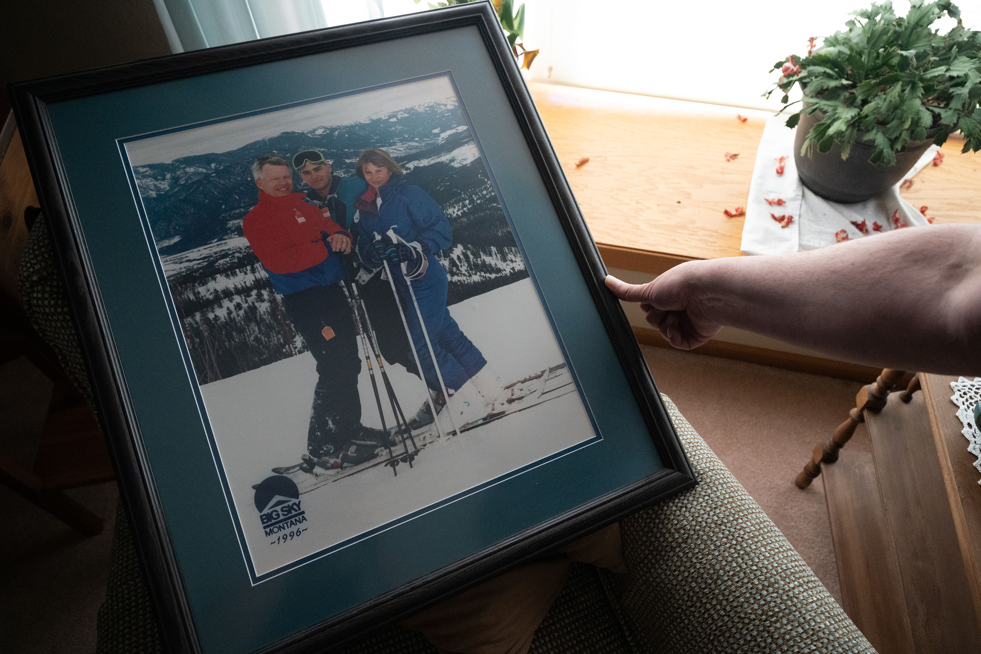 Casey Shively holds a photo of a family ski trip with his father, Dan, and his sister, Katie, in 1996.