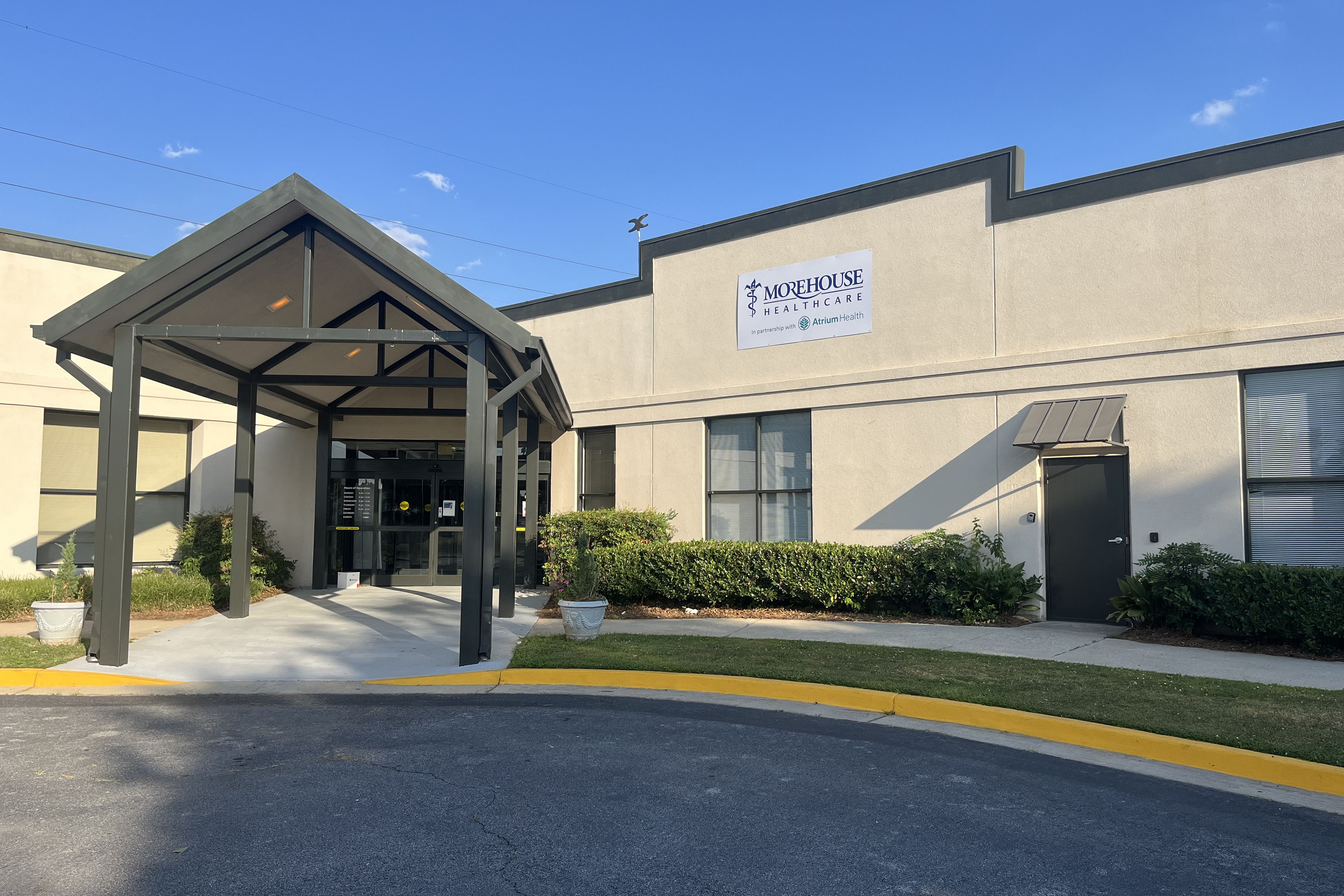 An exterior photograph of the Morehouse Healthcare building's entrance.