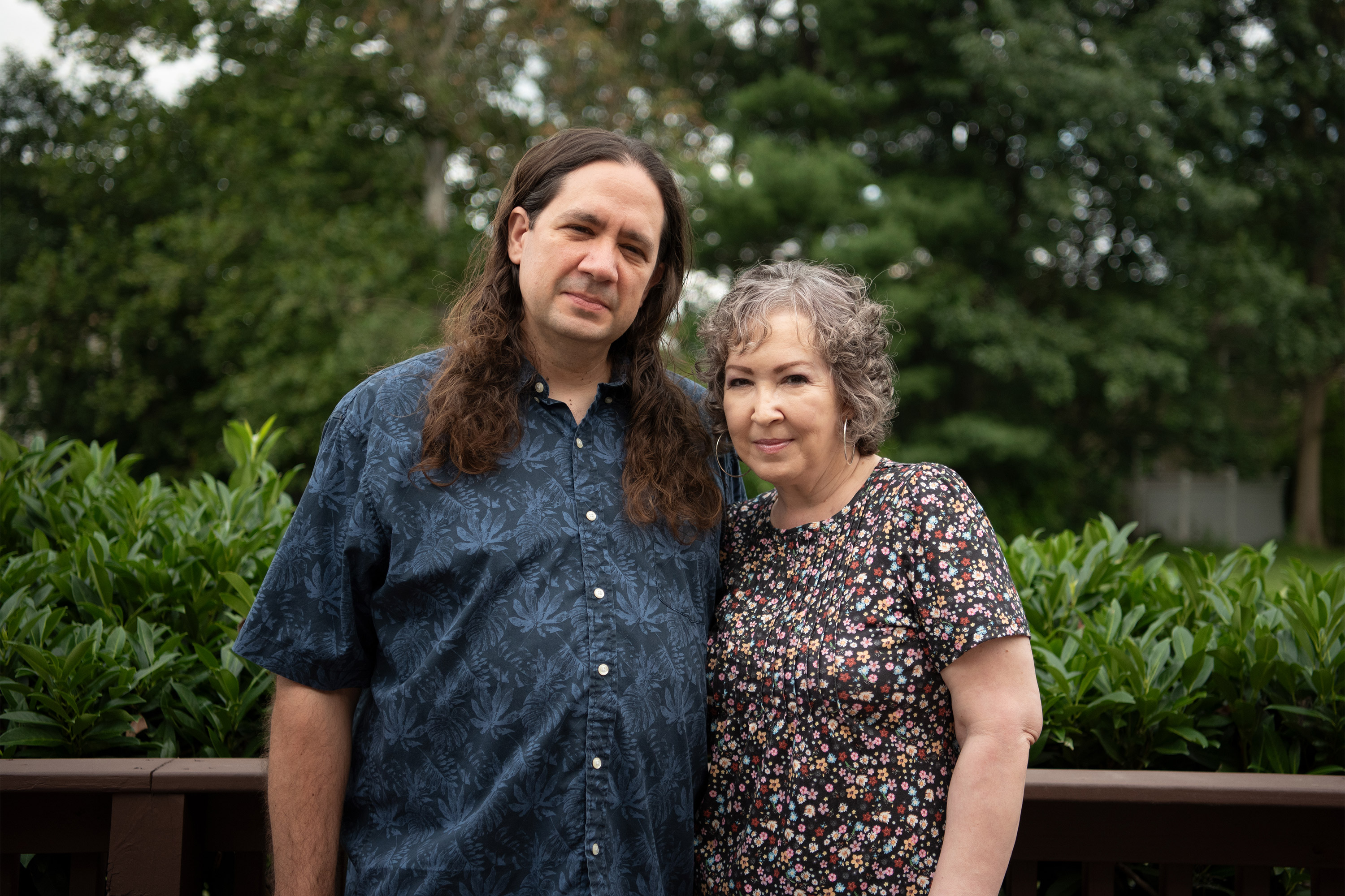 A photo of a woman standing outside with her husband.