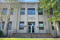 An exterior photograph of the Montana Department of Public Health and Human Services building on a sunny day.