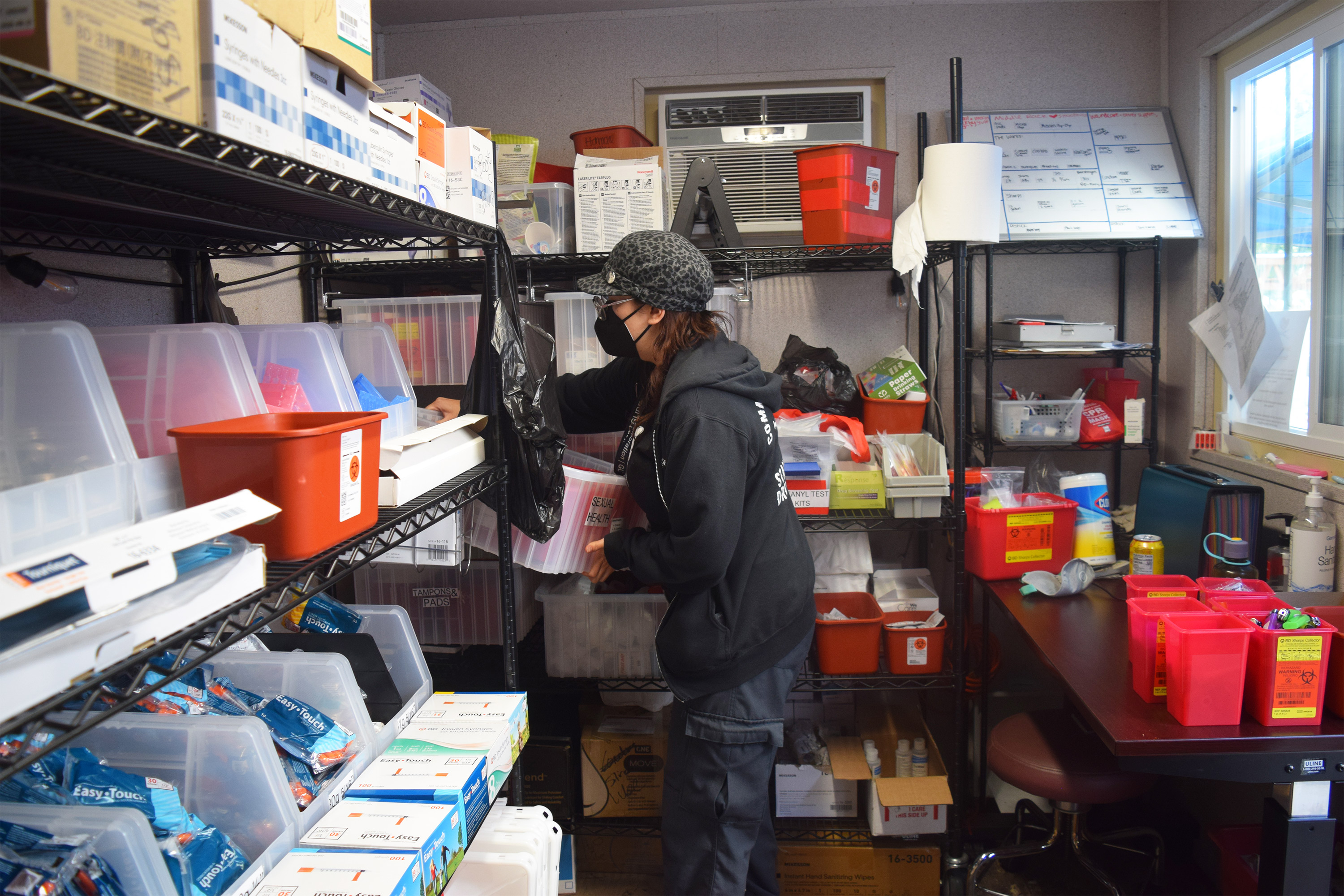 Foto de Sky Contreras entrando a un contenedor, rodeada de otras personas con suministros médicos.