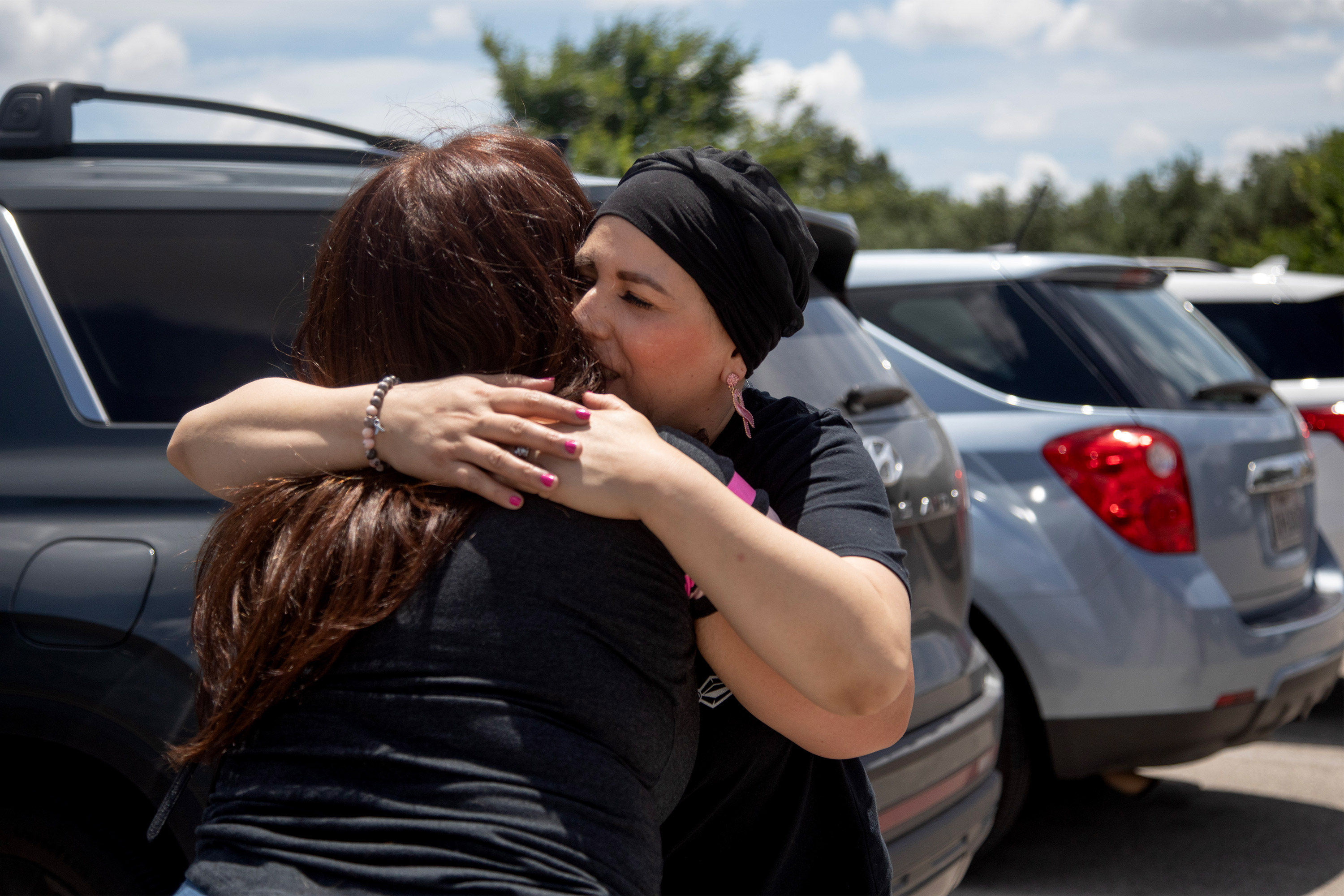 A photo of Herlinda Sanchez hugging her aunt in a parking lot.