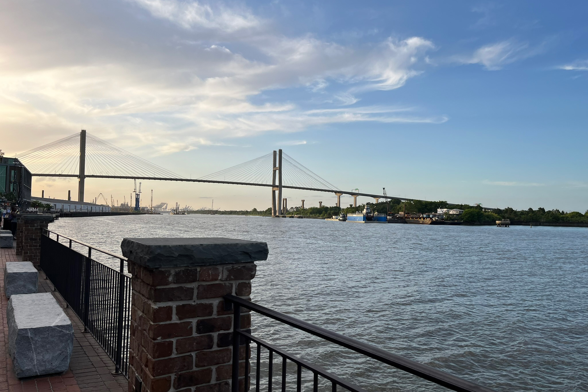 A view of the Talmadge Memorial Bridge at sunset from a path along the waterfront. 