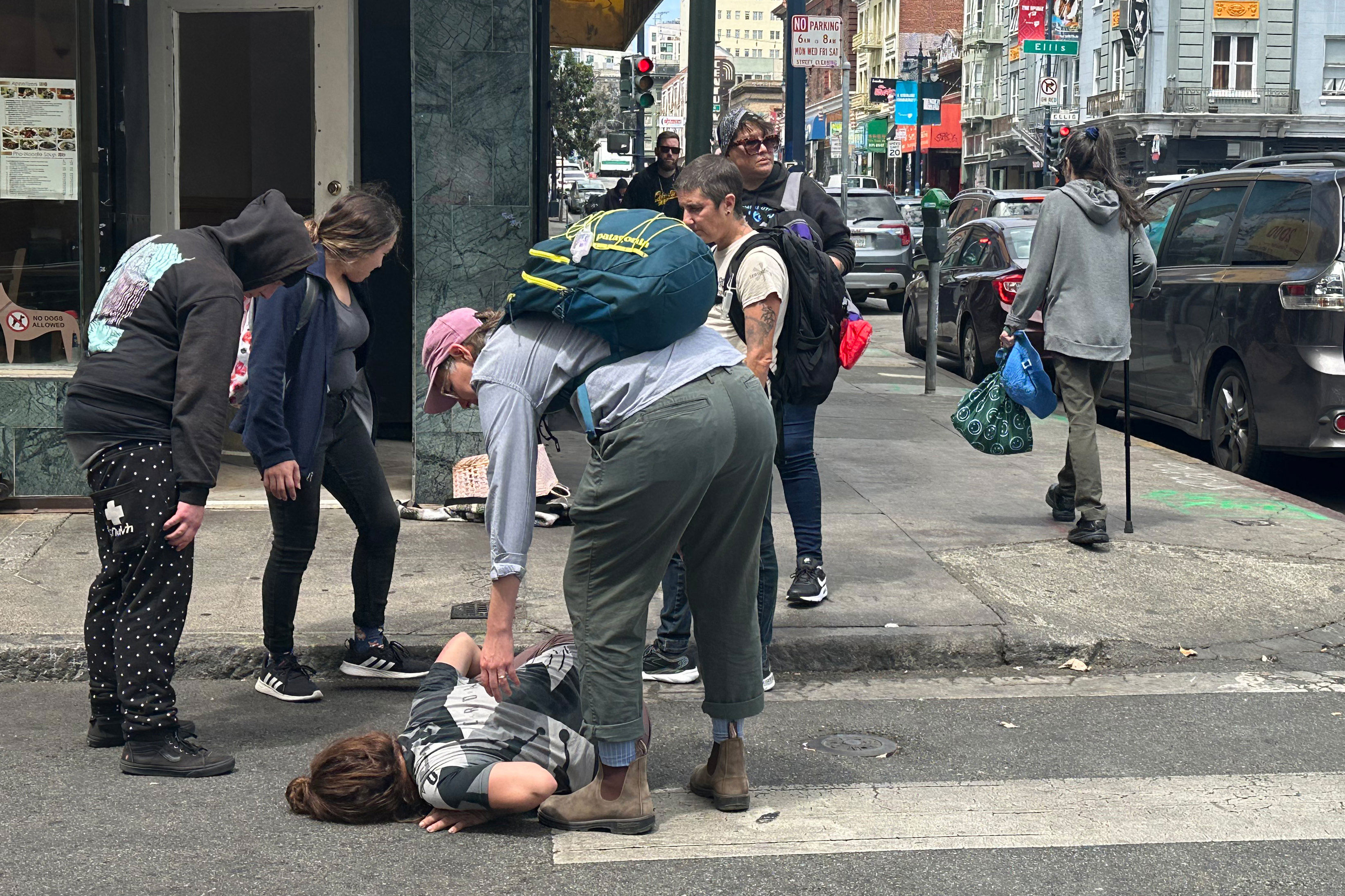 Health and Medical news A photo of a street medic tending to a woman lying on the street.