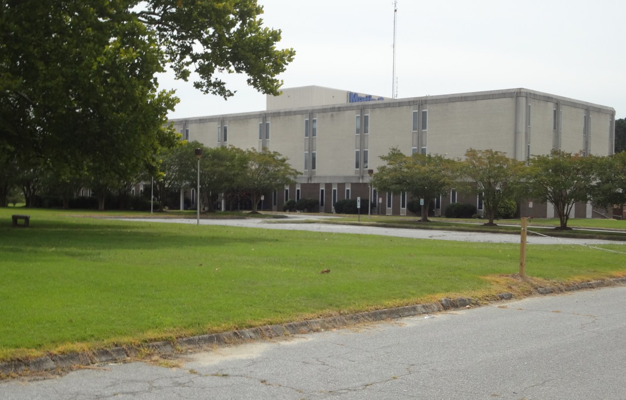 A large lawn with a hospital building in the background