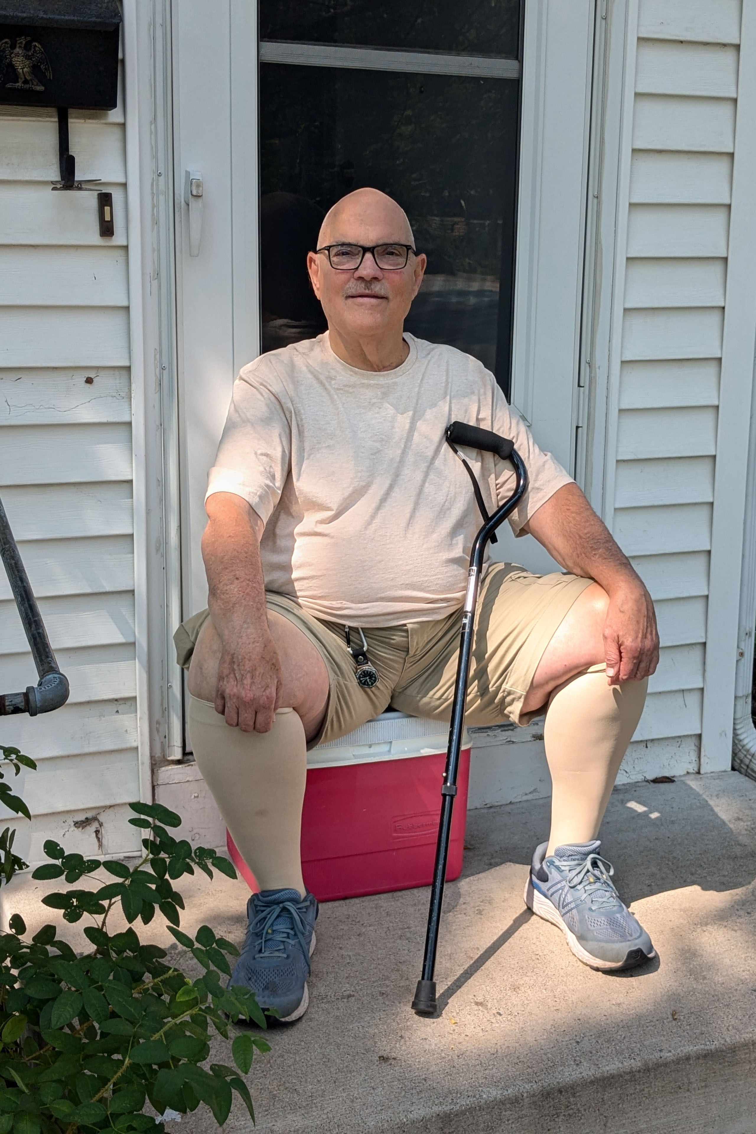 Donald Hammen, an 80 year old man, sits on the front steps to his house.