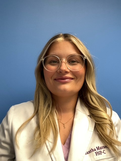 A portrait of a female doctor with long blonde hair and glasses.