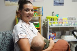 A portrait of Cailyn Morreale holding her infant in her arms.