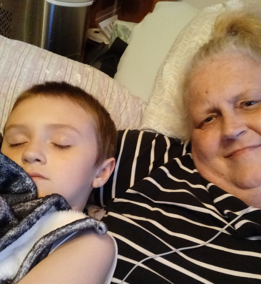 Photo of an old woman taking a photo with her young grandson.