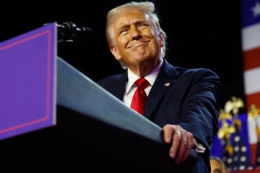 President Donald Trump holds a lectern before delivering his victory speech