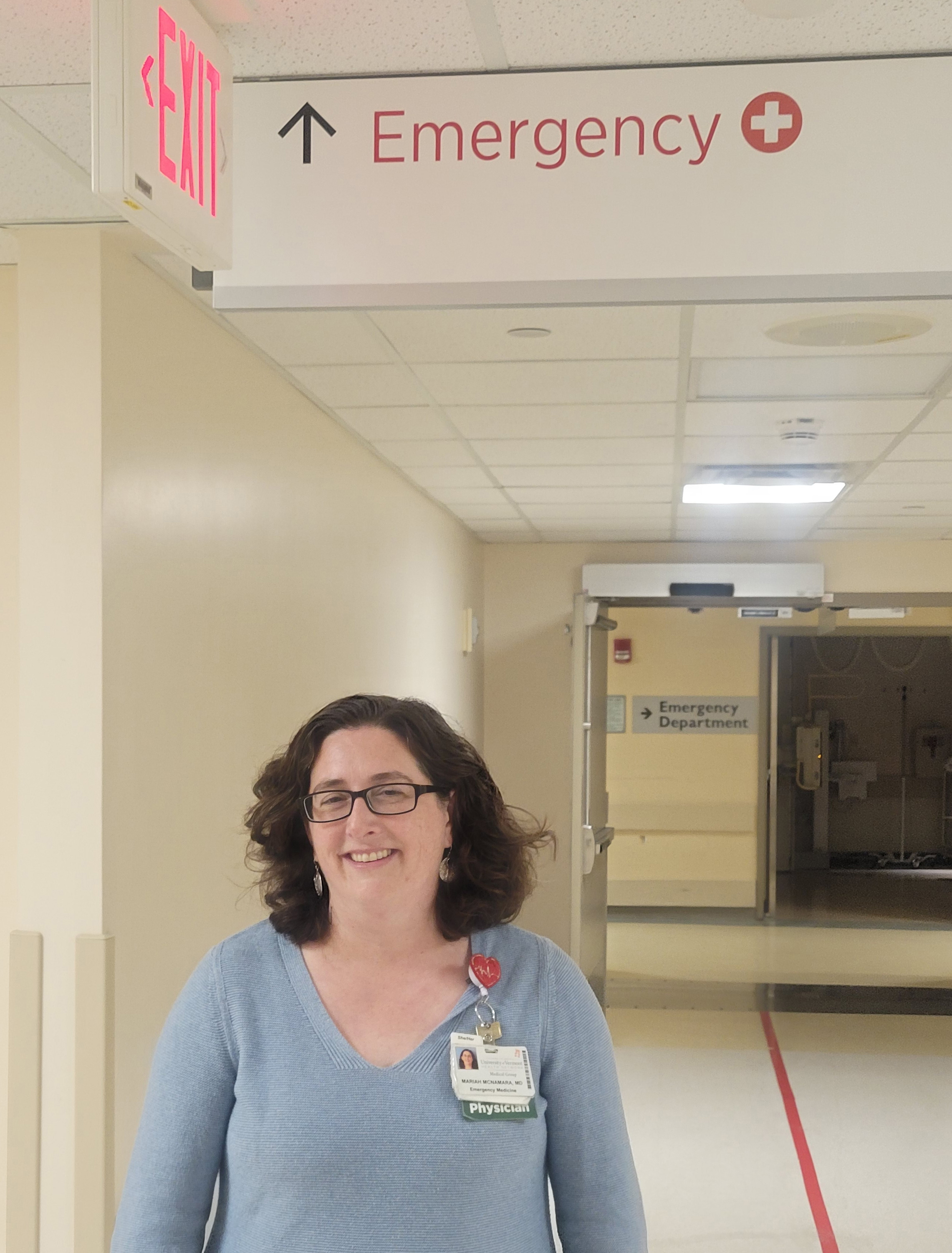 A photo of a doctor standing in an ER hallway.