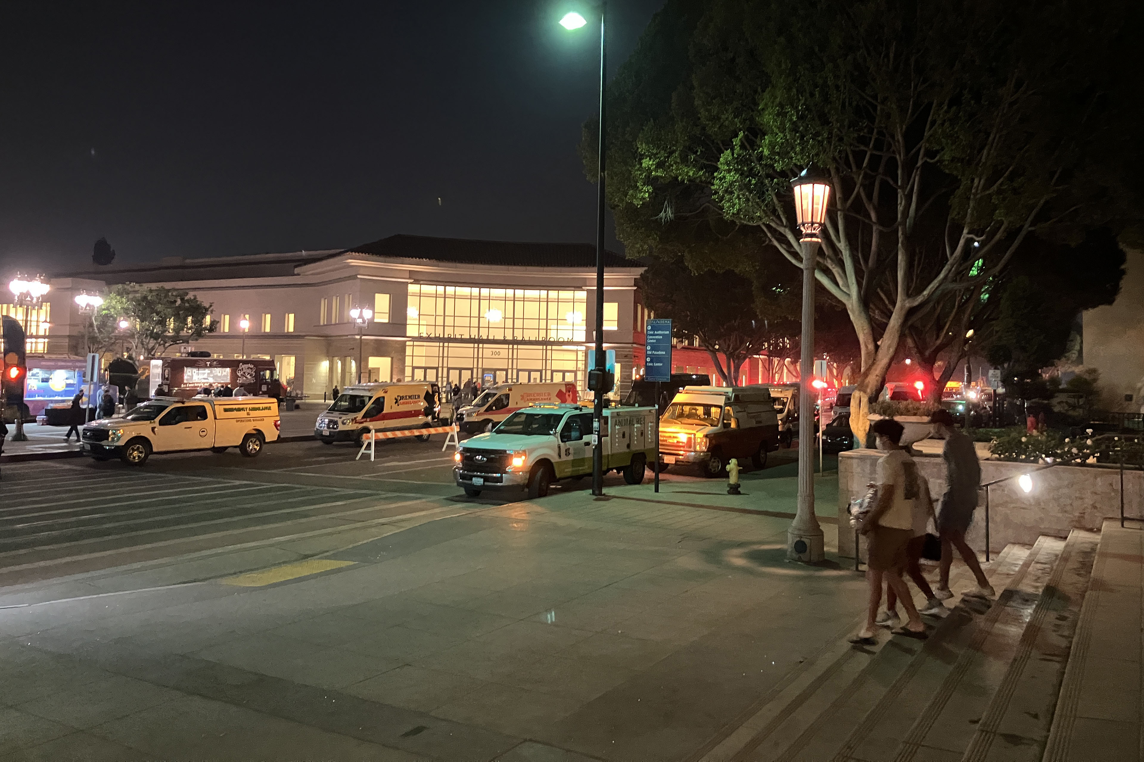 Emergency vehicles are parked in front of the Pasadena Convention Center after sundown