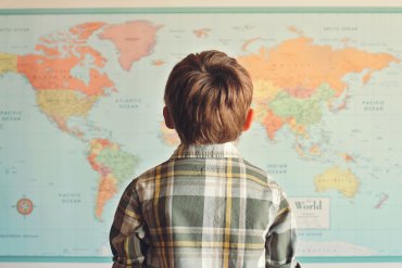 Little boy looking at world map.