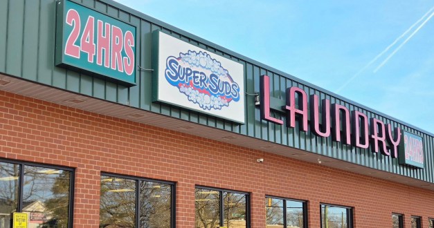 A photo of signage outside a laundromat: "24 hours, SuperSuds,laundry."