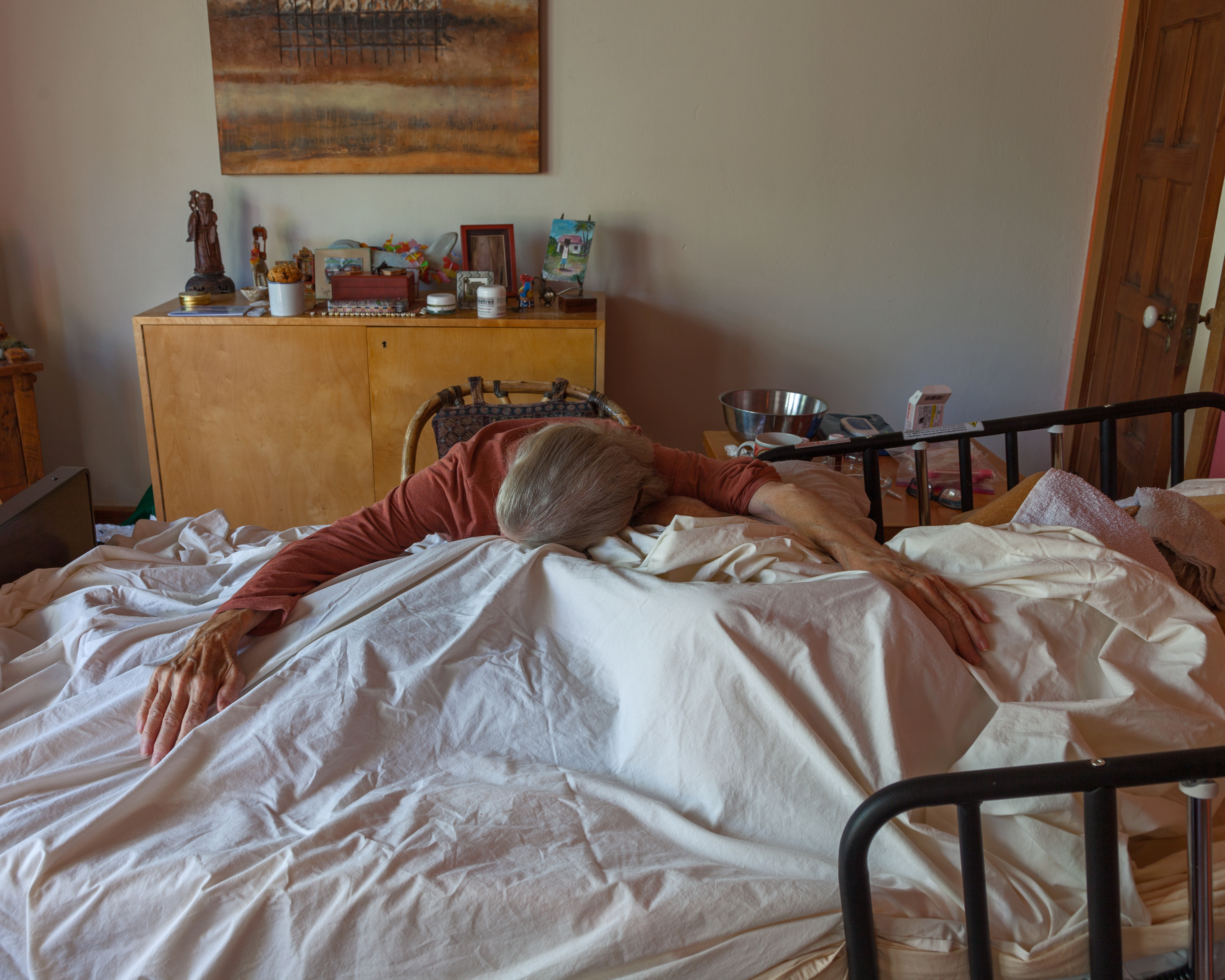 A photo shows Marna Clarke resting her head on her partner's deathbed.