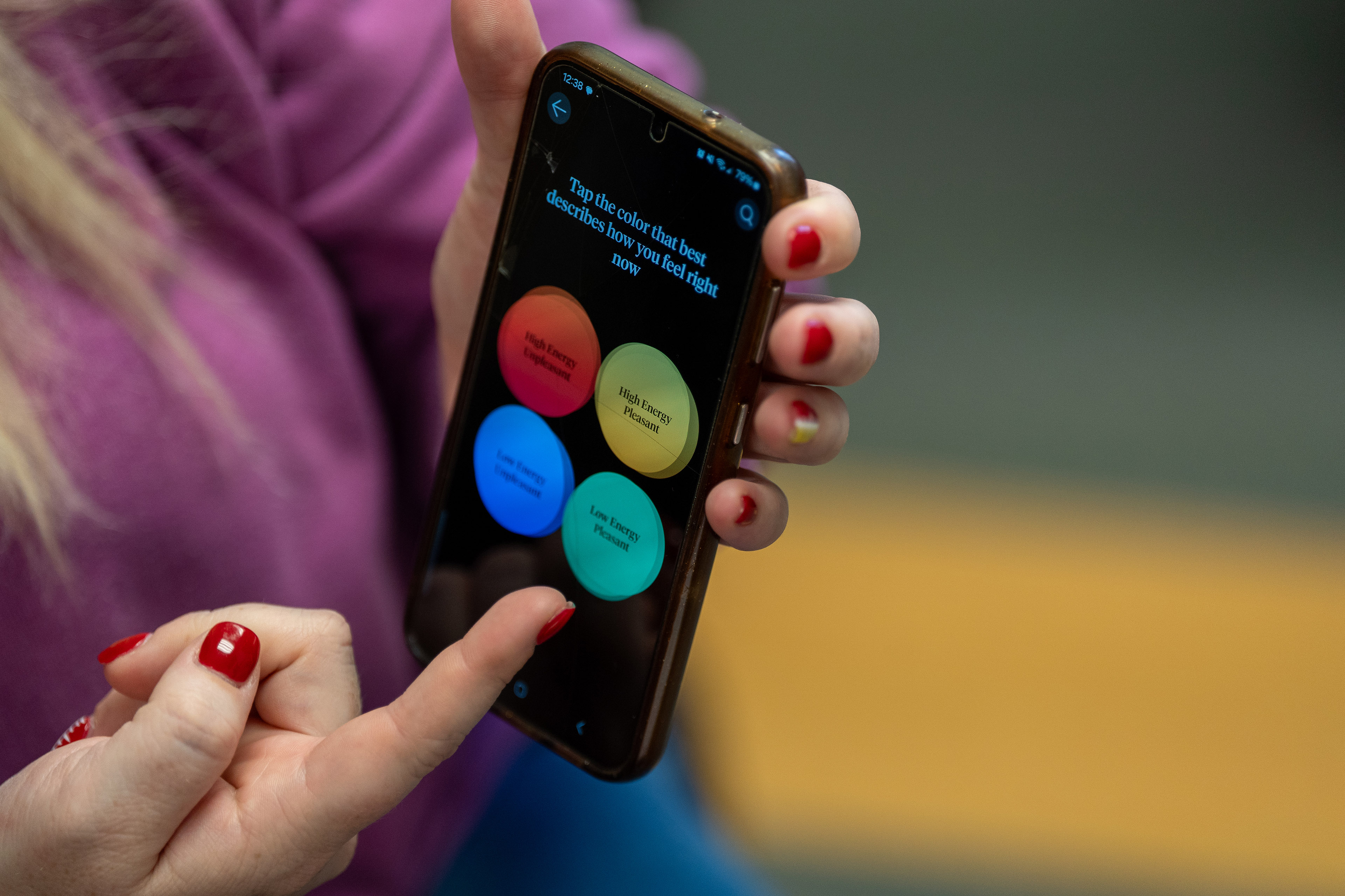 A woman points to a mental health app on her phone