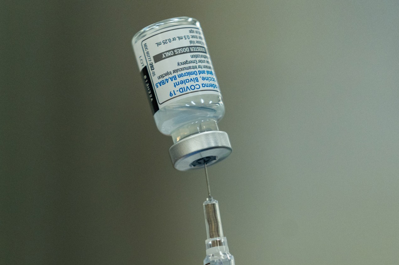 A close-up photo of a syringe inserted into a vial.