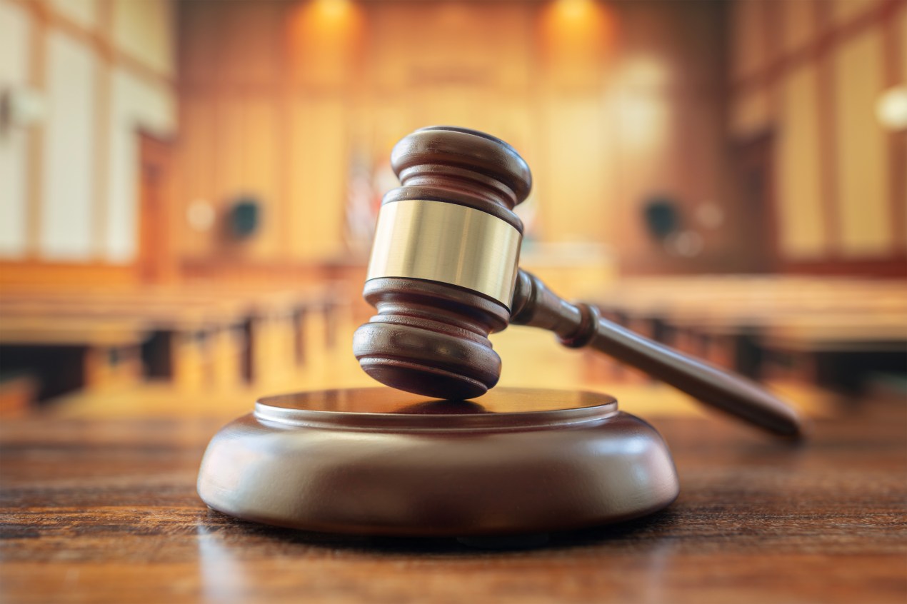 A photo of a gavel in a courtroom.