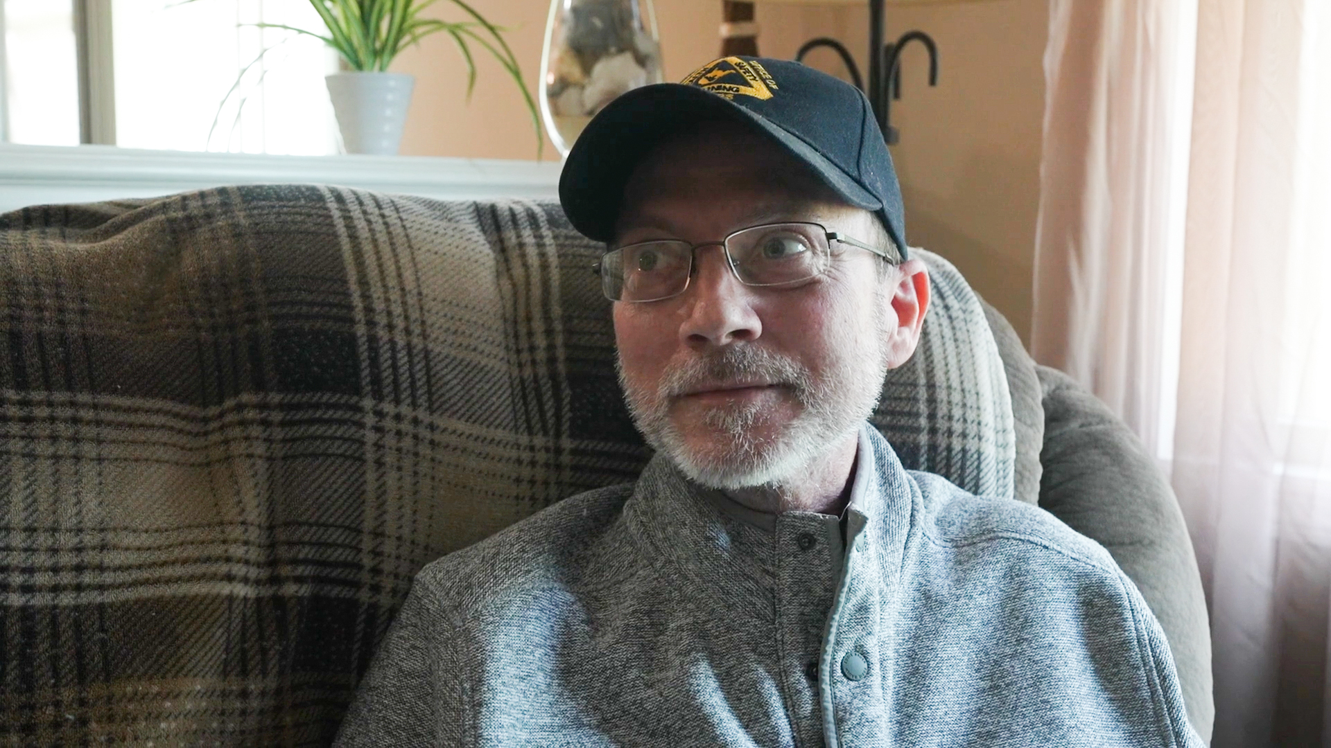 A photo of a man sitting in his living room.