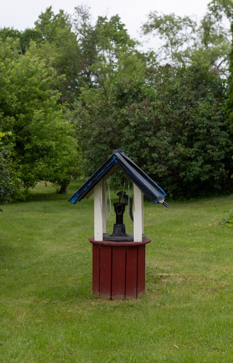 A photo of a water well in a grassy area.