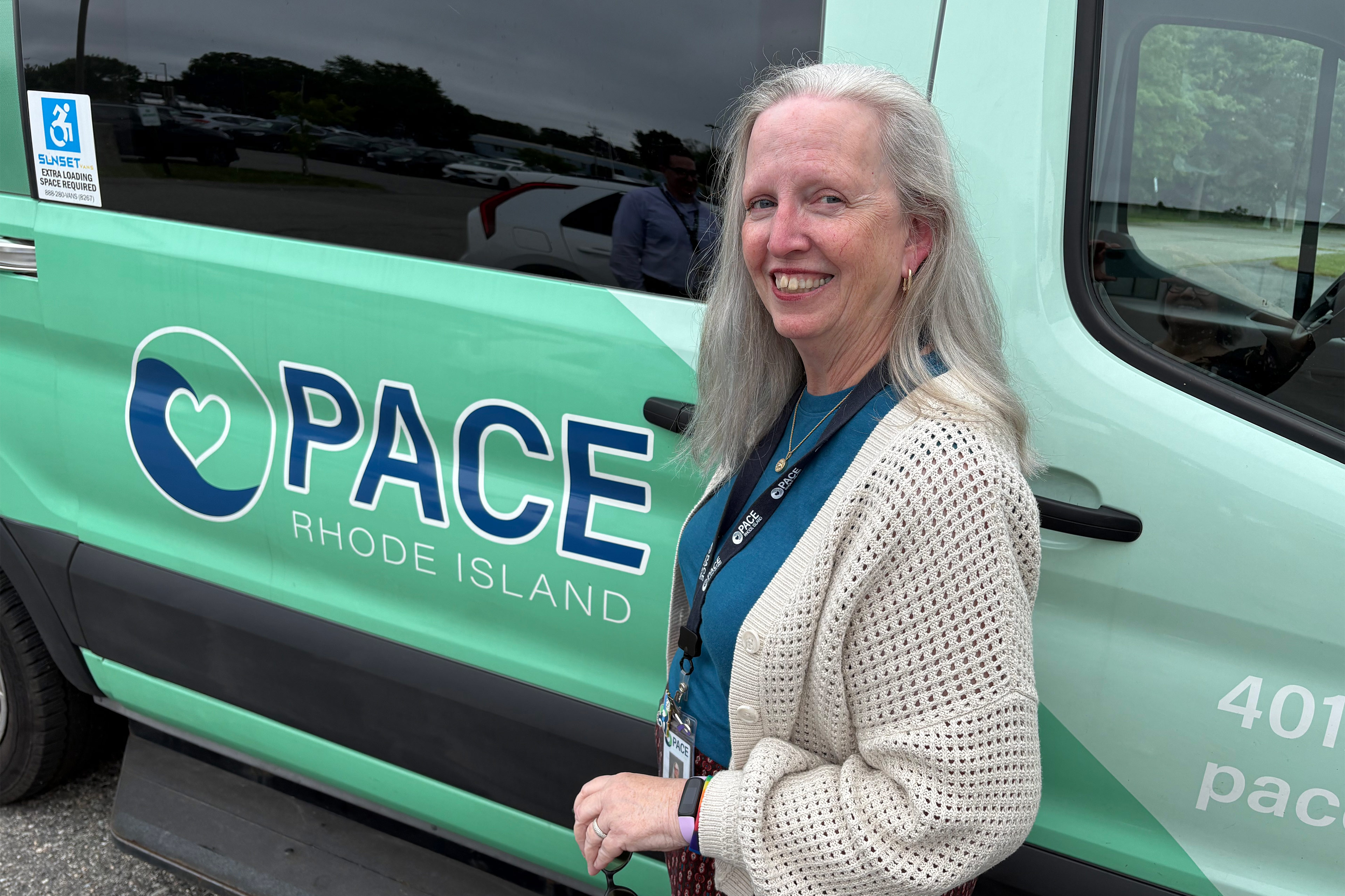 Ein Foto einer Frau, die vor einem Lieferwagen mit dem PACE-Logo steht.